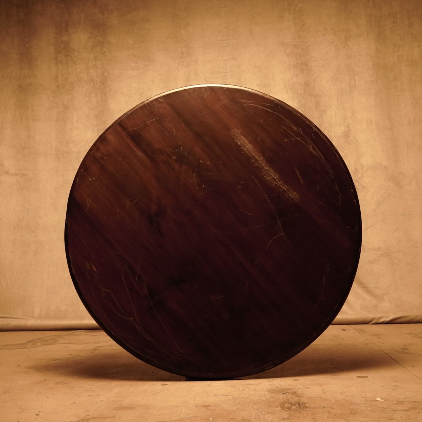 Tablero redondo de madera maciza oscura, estilo rústico vintage.