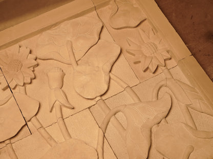 Panel decorativo de pared en piedra caliza con relieve floral natural, estilo boho rústico.